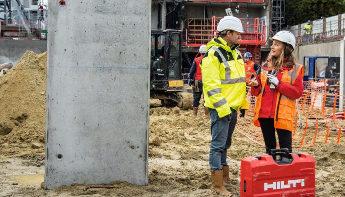 O representante de vendas da Hilti aconselha um cliente num estaleiro de obras